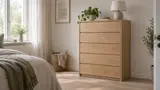 Byrå i ljus ek med fem lådor i ett ljust skandinaviskt sovrum